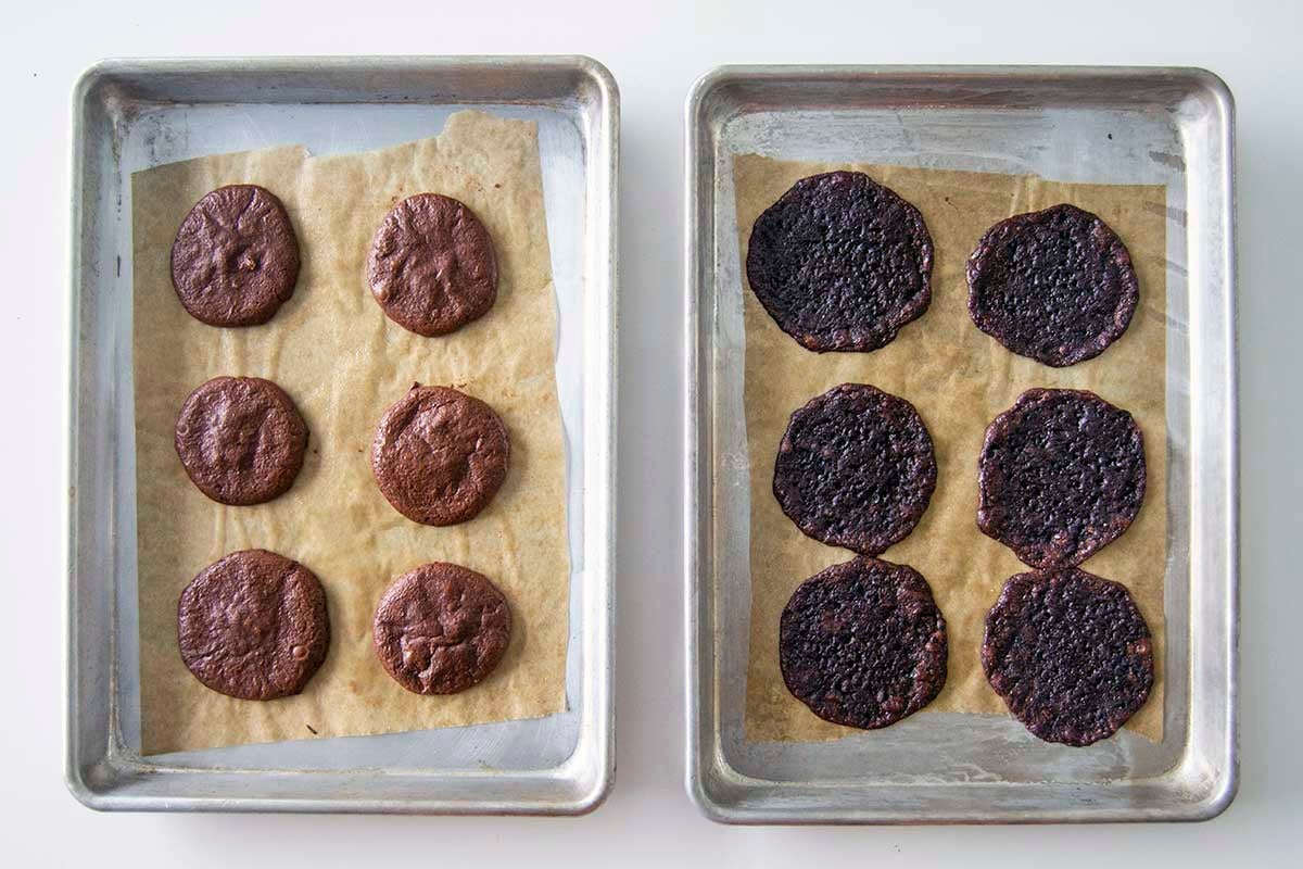 Pan of egg white chocolate crinkle cookies next to pan of messy, sticky, poorly baked aquafaba chocolate crinkle cookies